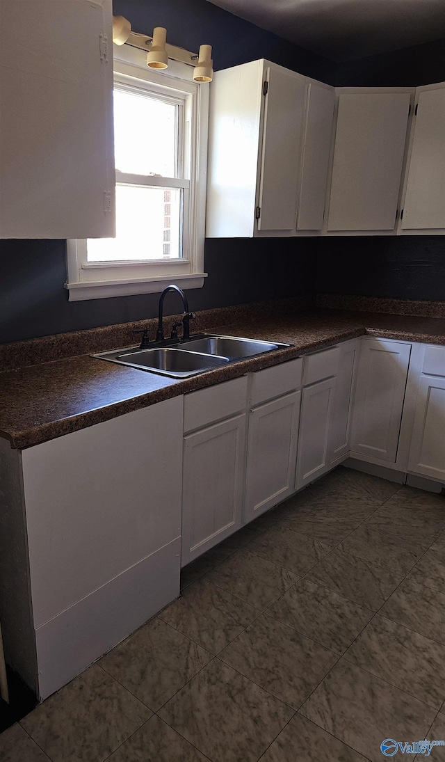 kitchen featuring white cabinetry and sink