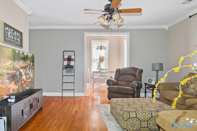 living area with crown molding, baseboards, ceiling fan, and wood finished floors