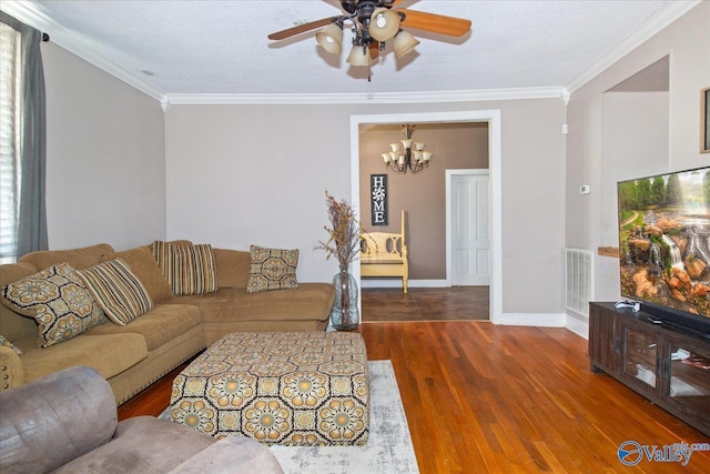 living room with ornamental molding, wood finished floors, visible vents, and baseboards