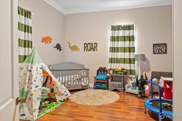 bedroom with wood finished floors and crown molding