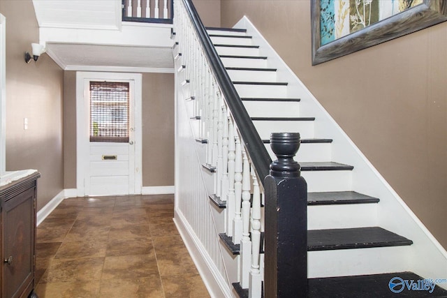 staircase featuring ornamental molding and baseboards