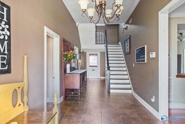 foyer entrance featuring an inviting chandelier, ornamental molding, dark tile patterned floors, baseboards, and stairs