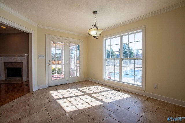 doorway with crown molding, plenty of natural light, and light tile patterned flooring