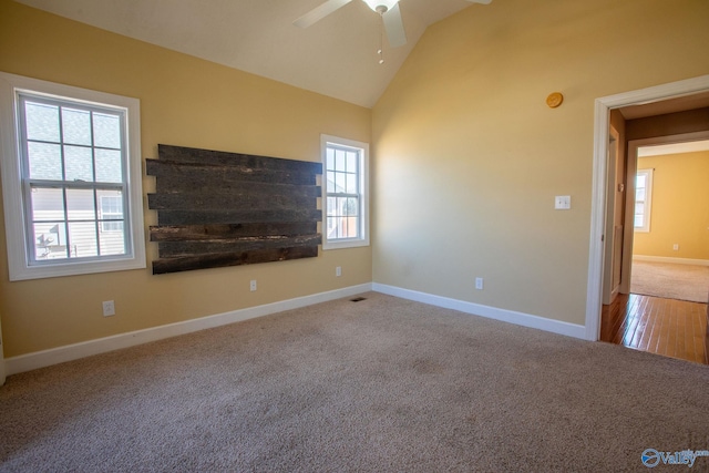 unfurnished living room with high vaulted ceiling, light colored carpet, and ceiling fan