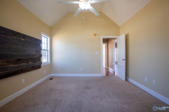 carpeted empty room with high vaulted ceiling and ceiling fan