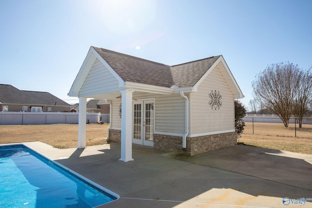 exterior space with french doors, an outbuilding, a fenced in pool, and a patio area