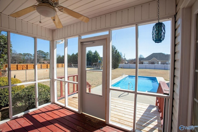 unfurnished sunroom with ceiling fan