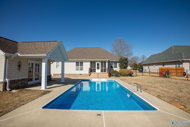 view of pool with a patio, a yard, and french doors