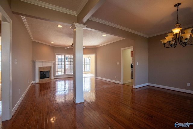 unfurnished living room with decorative columns, ornamental molding, dark hardwood / wood-style floors, a high end fireplace, and ceiling fan with notable chandelier