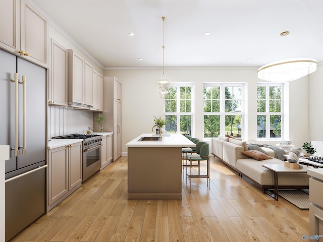 6103C Randolph Ave Unit 3C, Huntsville, AL 35801 - kitchen featuring high end appliances, light countertops, crown molding, a kitchen island with sink, and light wood-type flooring