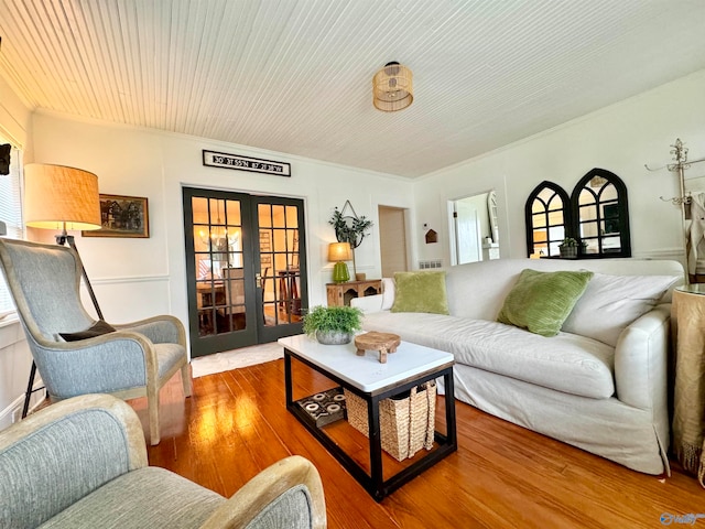 living room with plenty of natural light, french doors, crown molding, and wood-type flooring