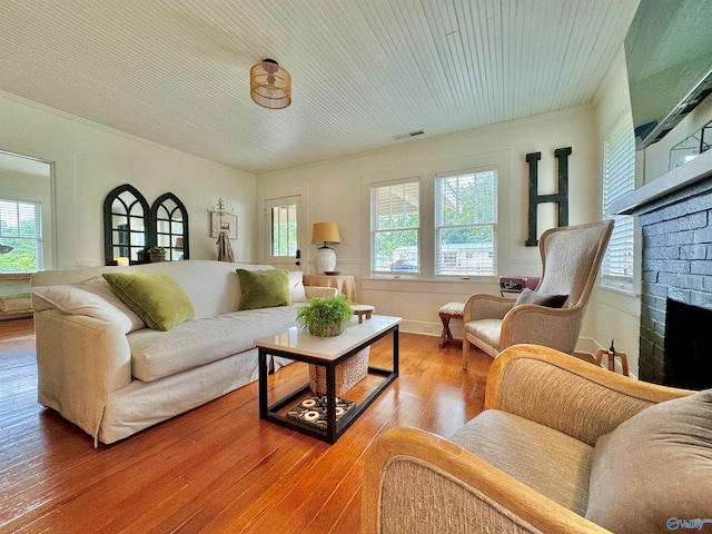 living room with hardwood / wood-style floors and a brick fireplace