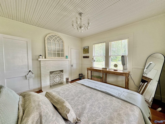 bedroom with a chandelier, wood ceiling, a fireplace, and wood finished floors