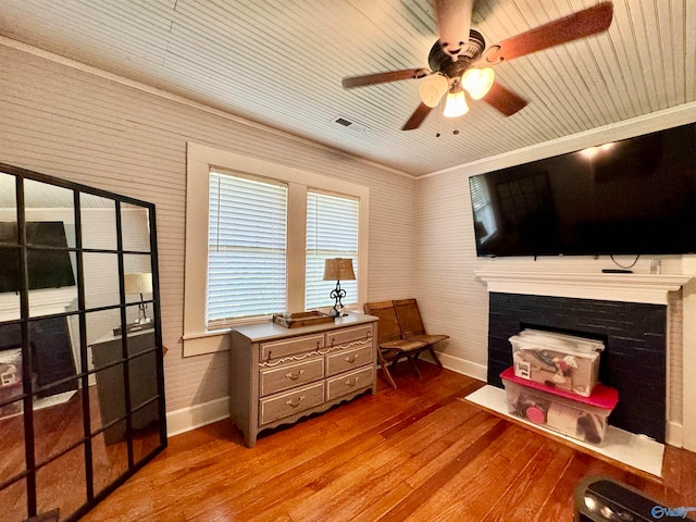 interior space featuring ceiling fan, a fireplace, and wood-type flooring