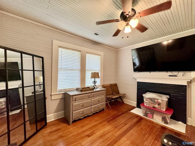 living area with a fireplace, wood finished floors, and baseboards