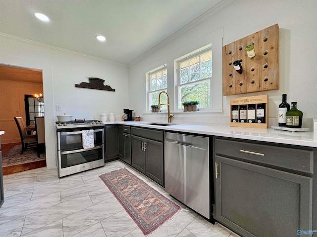 kitchen with appliances with stainless steel finishes, crown molding, light tile patterned flooring, and sink