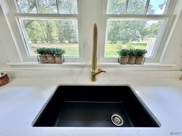 interior details featuring sink and light stone countertops