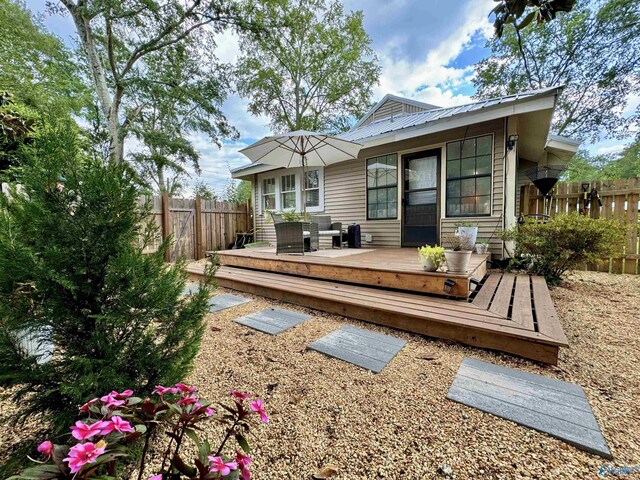 rear view of property featuring a wooden deck