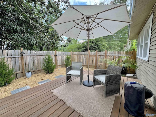 wooden terrace with a fenced backyard