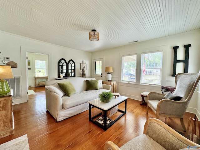 living room featuring visible vents, wood-type flooring, and a wealth of natural light