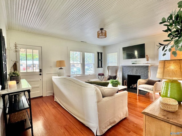 living room with hardwood / wood-style floors, a wealth of natural light, and a fireplace