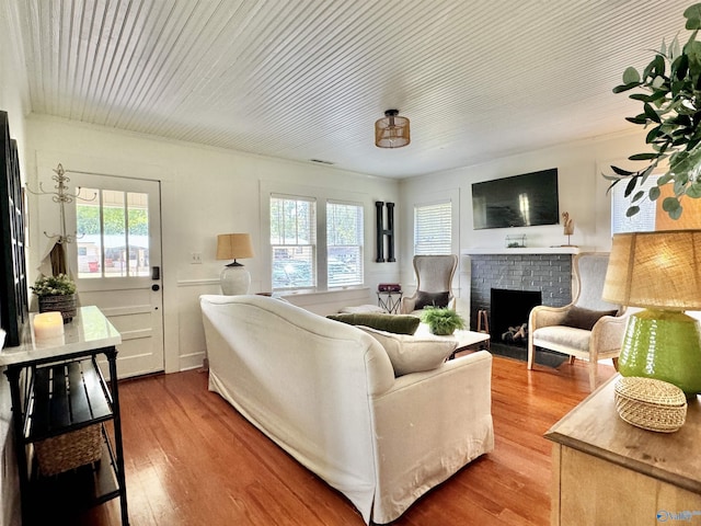 living area featuring a brick fireplace and wood finished floors