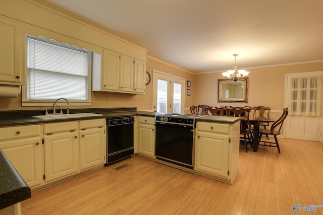 kitchen with dark countertops, black appliances, a peninsula, and a sink