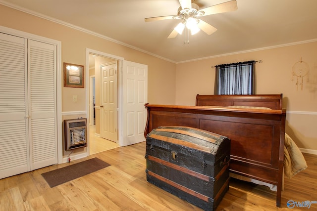 bedroom featuring ornamental molding, light wood-type flooring, and heating unit