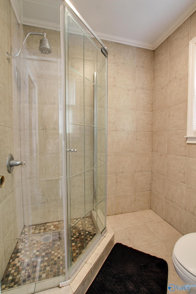 full bathroom featuring a stall shower, crown molding, and toilet