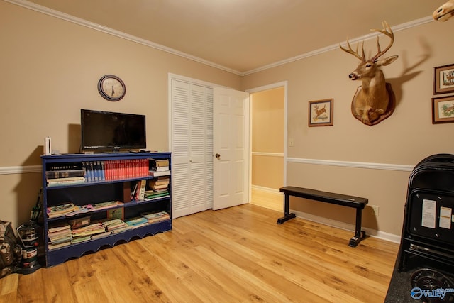 interior space with baseboards, crown molding, and wood finished floors