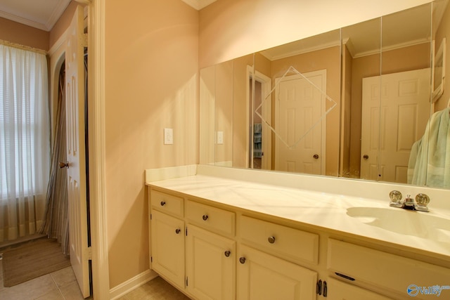 bathroom featuring tile patterned flooring, crown molding, vanity, and baseboards