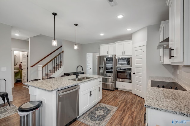 kitchen featuring backsplash, wood-type flooring, an island with sink, white cabinetry, and black appliances