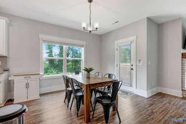 dining area featuring hardwood / wood-style flooring and an inviting chandelier