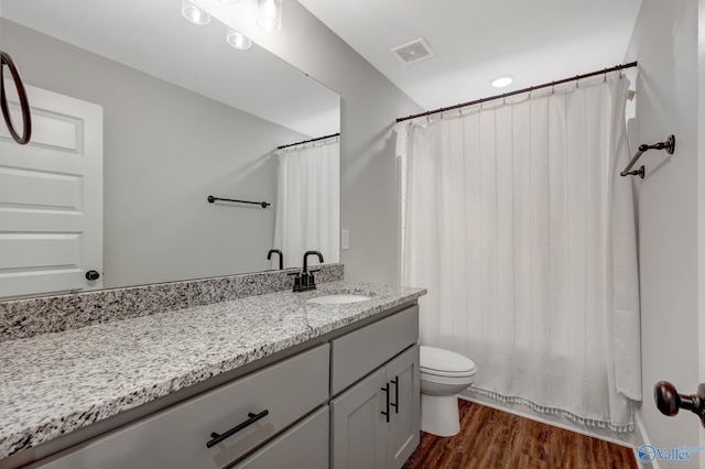 bathroom with hardwood / wood-style flooring, vanity, and toilet