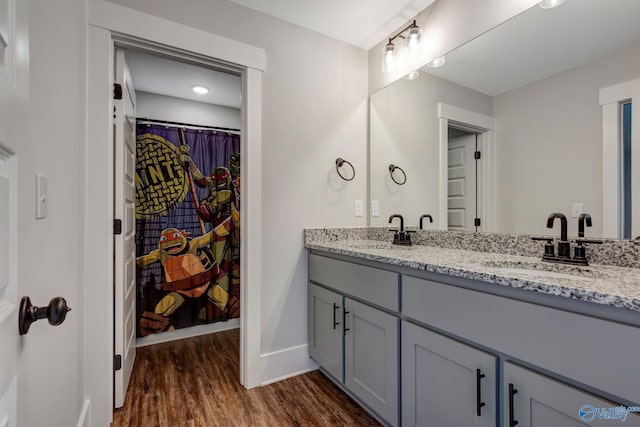 bathroom featuring double sink vanity and wood-type flooring