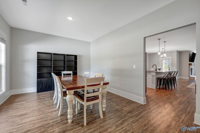 dining room with hardwood / wood-style floors and a chandelier