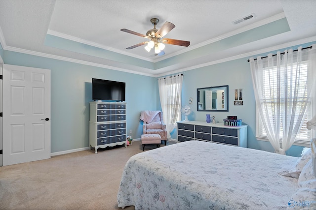 bedroom featuring ornamental molding, light carpet, visible vents, a tray ceiling, and ceiling fan