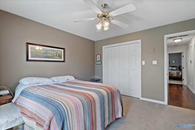 carpeted bedroom with visible vents, a closet, baseboards, and ceiling fan