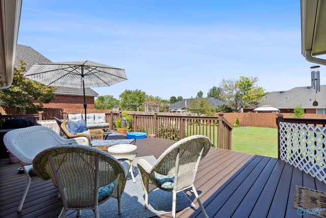 deck featuring outdoor lounge area, fence, and a lawn