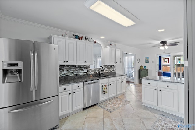 kitchen featuring crown molding, appliances with stainless steel finishes, a sink, and white cabinets
