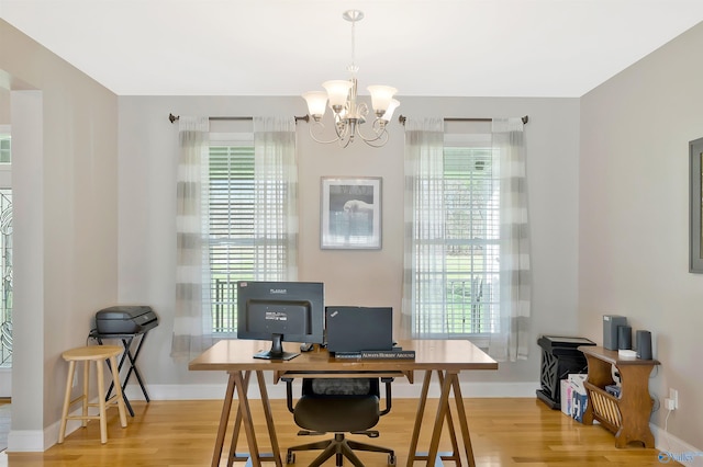 office featuring wood finished floors, a notable chandelier, and baseboards