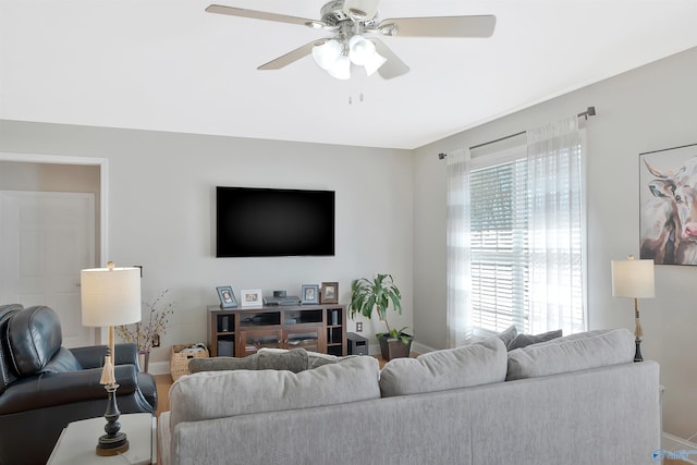 living room with ceiling fan and baseboards