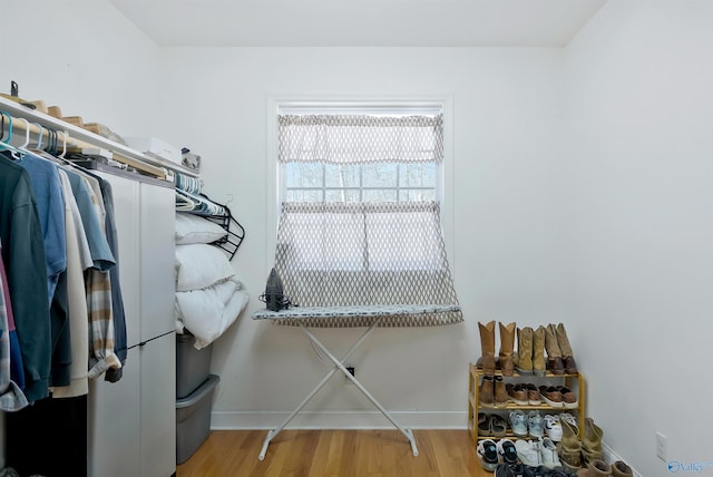 walk in closet with wood finished floors