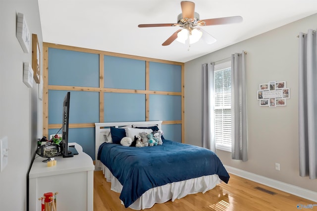 bedroom with visible vents, light wood-type flooring, a ceiling fan, and baseboards
