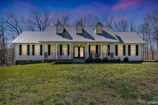 cape cod home featuring covered porch, metal roof, and a yard