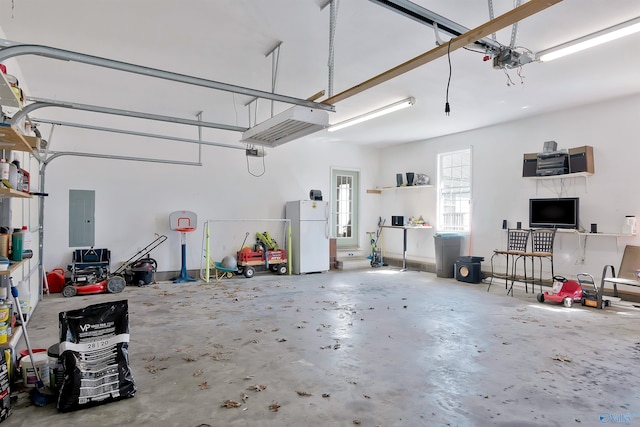 garage with a garage door opener, electric panel, and freestanding refrigerator