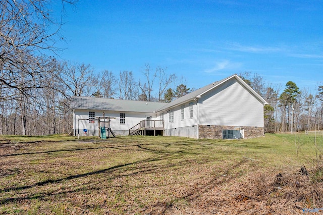 back of house with central AC unit and a lawn