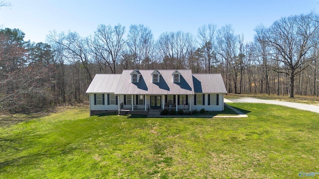 view of front of home featuring a wooded view, metal roof, covered porch, a front yard, and crawl space