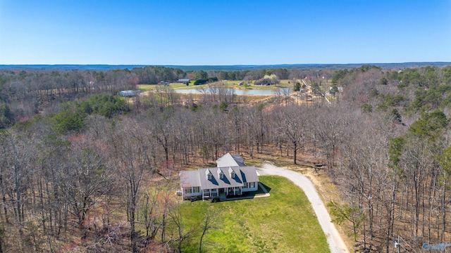 birds eye view of property featuring a forest view and a water view