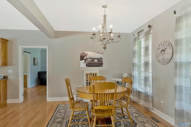 dining room with visible vents, an inviting chandelier, baseboards, and light wood-style floors
